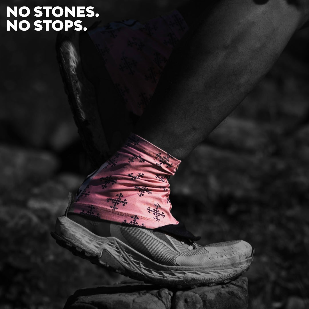 Close-up of a runner wearing Ahon’s Apo 1 Trail Running Gaiters in pink-orange, shielding trail shoes from rocks and debris.