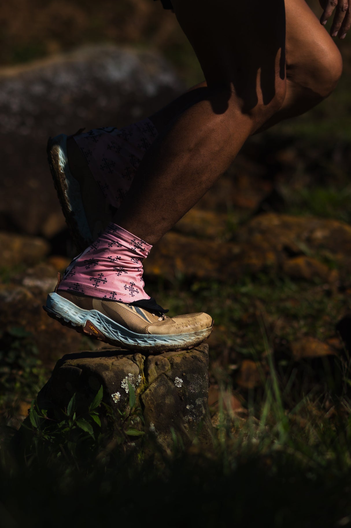 Trail runner wearing Apo 1 Gaiters on rocky terrain, showing secure fit and protection.