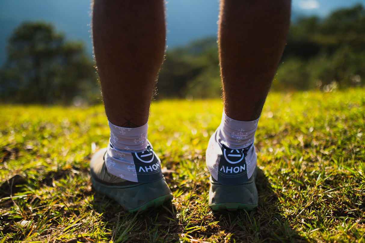 Trail runner wearing Ahon gaiters in sunlight during mountain run