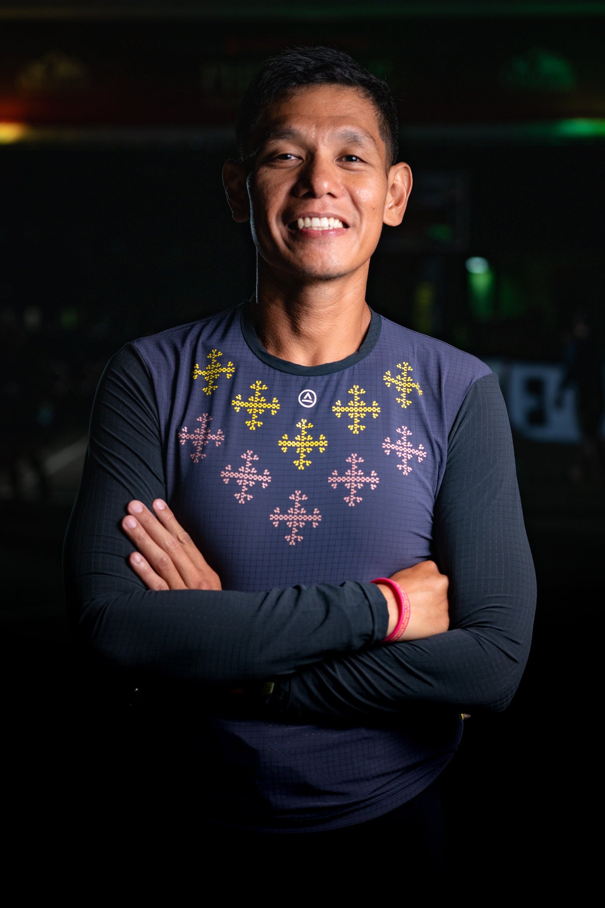 Male trail runner smiling while wearing the Apo Super Light LS Shirt in Dark Purple with printed design