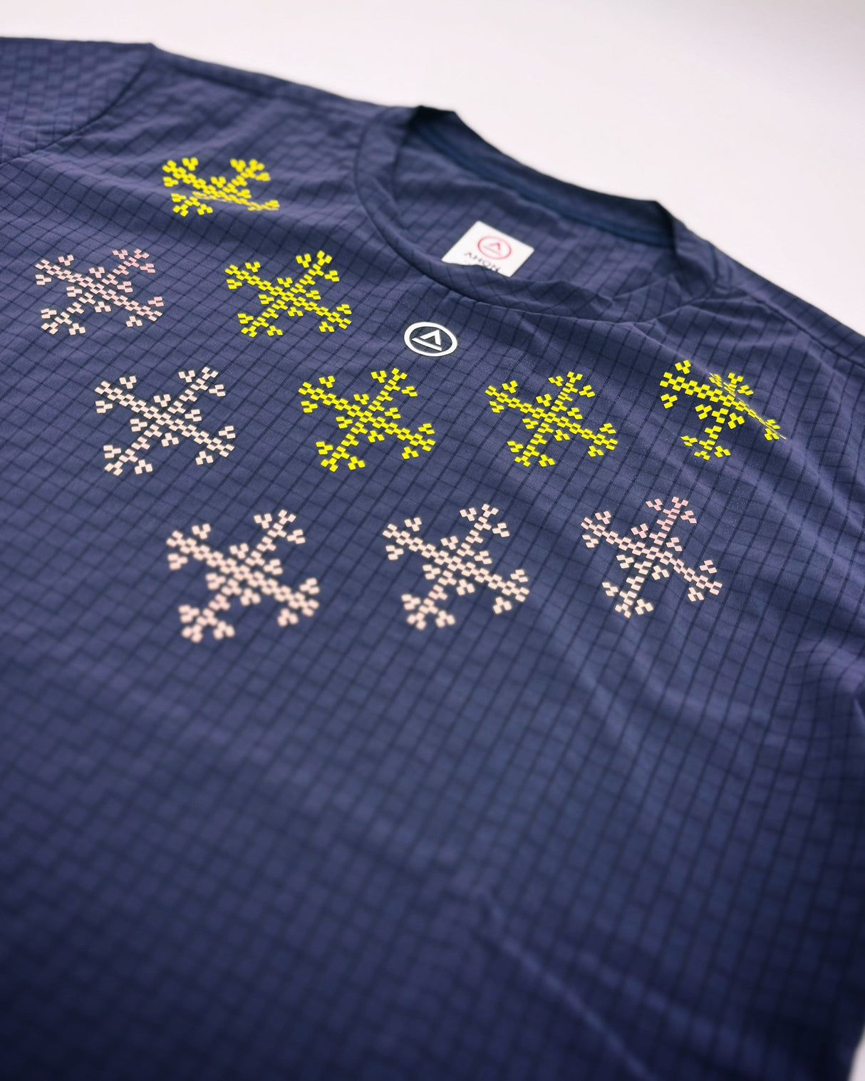 Flat lay of the Apo Super Light Shirt showing traditional-weaving-inspired design on chest