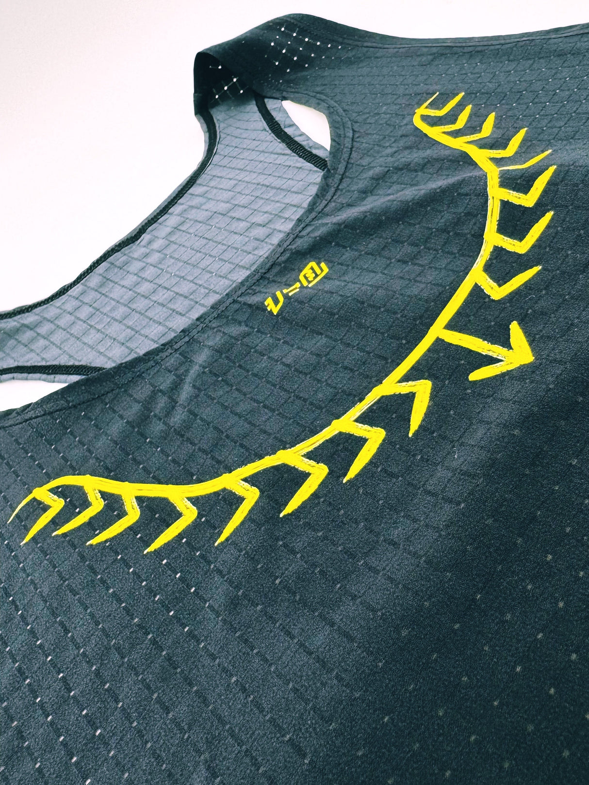 Close-up of lightweight mesh texture and yellow detail on Ahon Koling singlet
