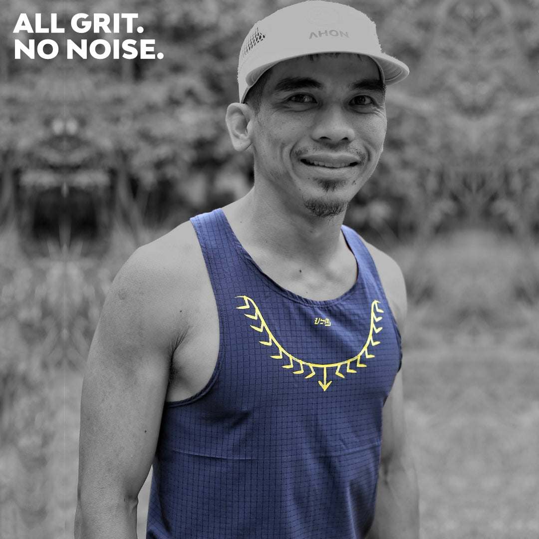 Male trail runner wearing Ahon Koling Super Light Singlet black front, yellow print design