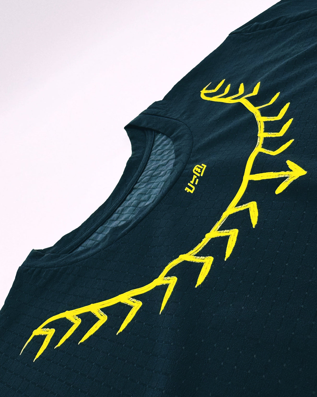 Detailed shot of tattoo-inspired yellow neck graphic on the Koling Super Light SS Shirt by Ahon