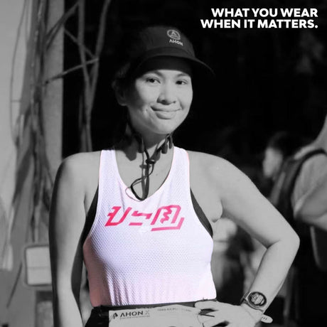 Female trail runner wearing the KSU Singlet 2 by Ahon during a night trail event