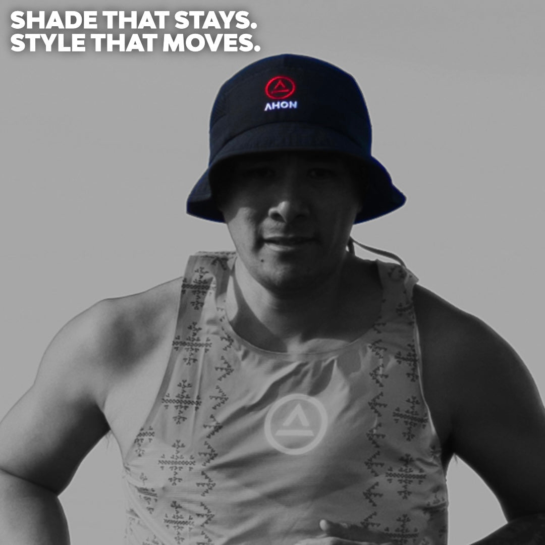 Model wearing the Ahon Logo Bucket Hat in black on trail background