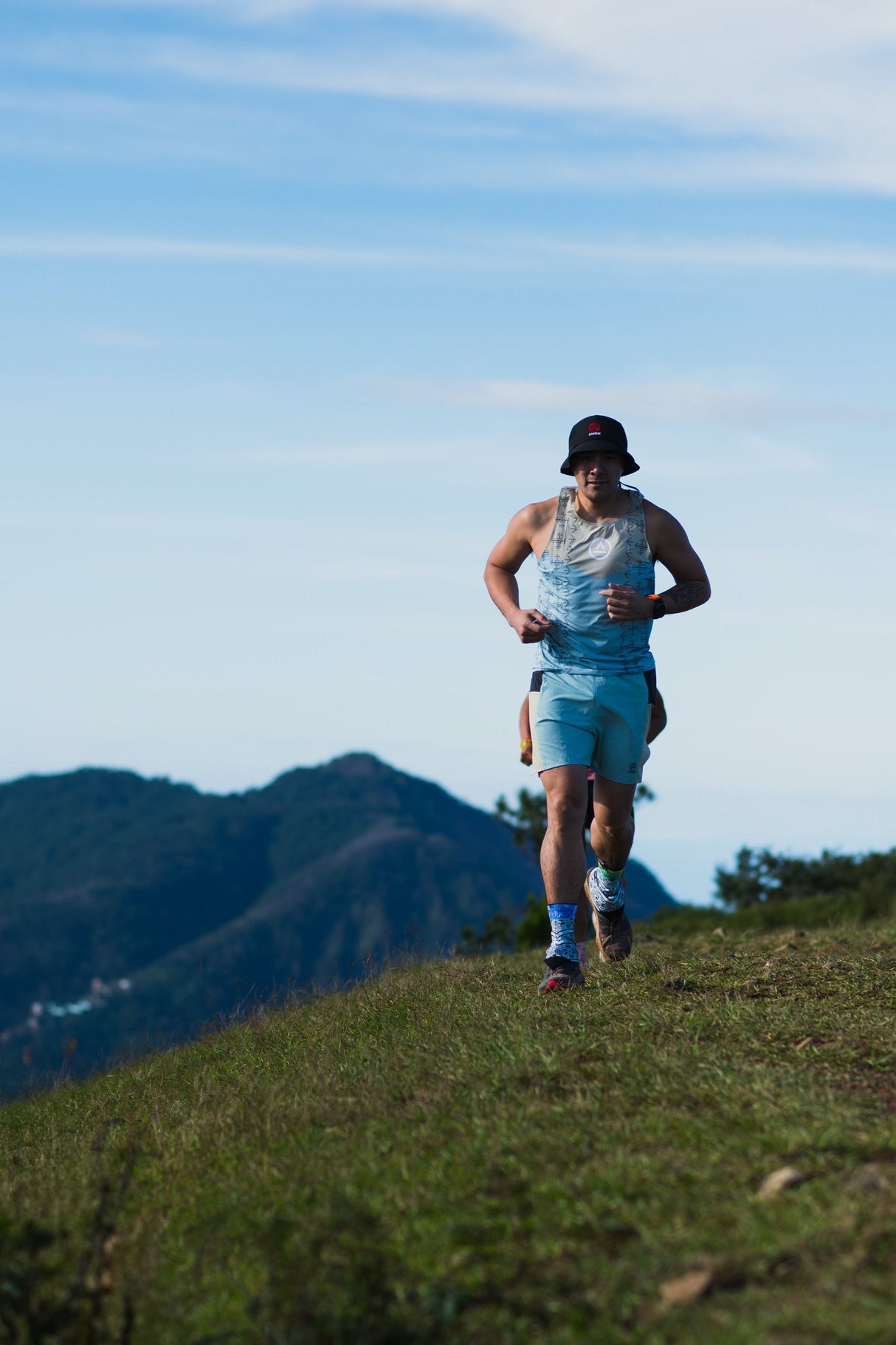 male trail runners on a ridge wearing Singlet Pro (colorway 2)