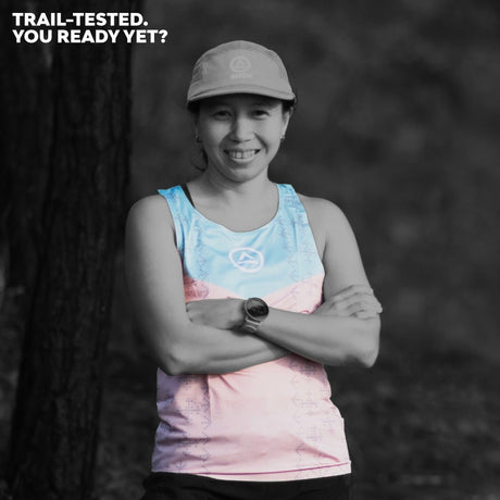 Trail runner smiling in Singlet Pro Colorway 3 with forest background – front view