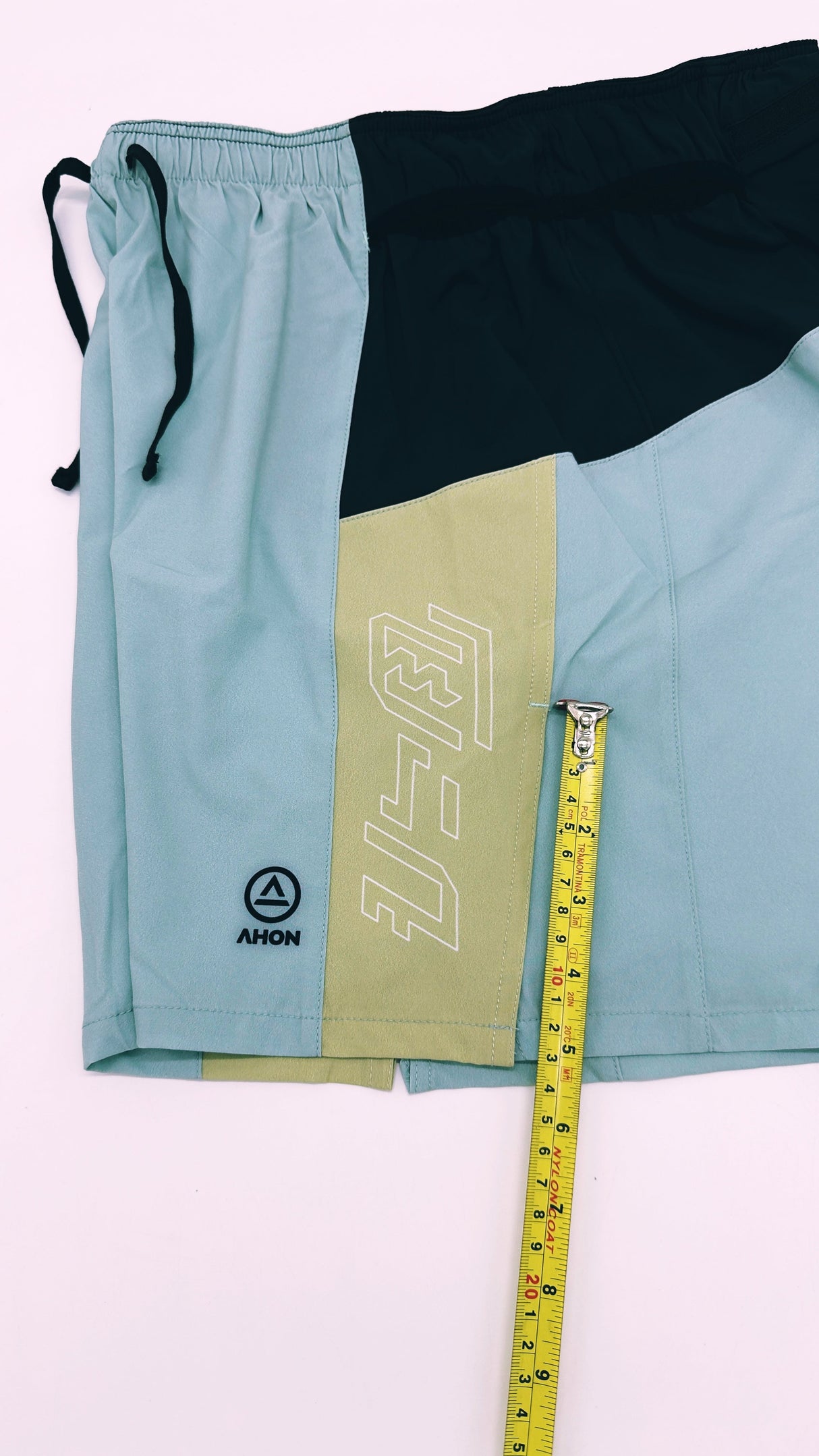 Close-up of Ahon Trail Shorts Pro logo and split side design in Colorway 2