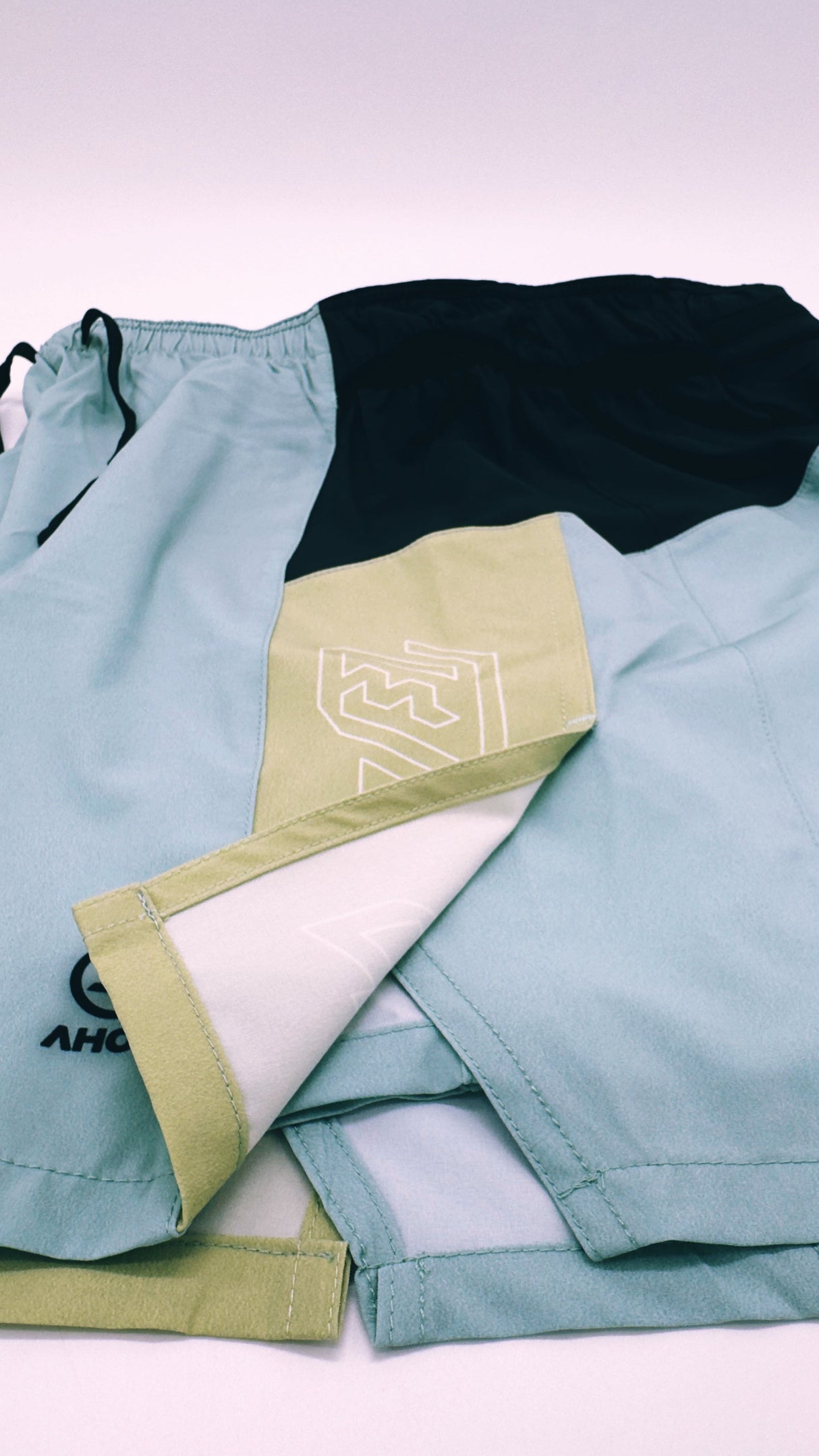 Close-up of Ahon Trail Shorts Pro logo and split side design in Colorway 2