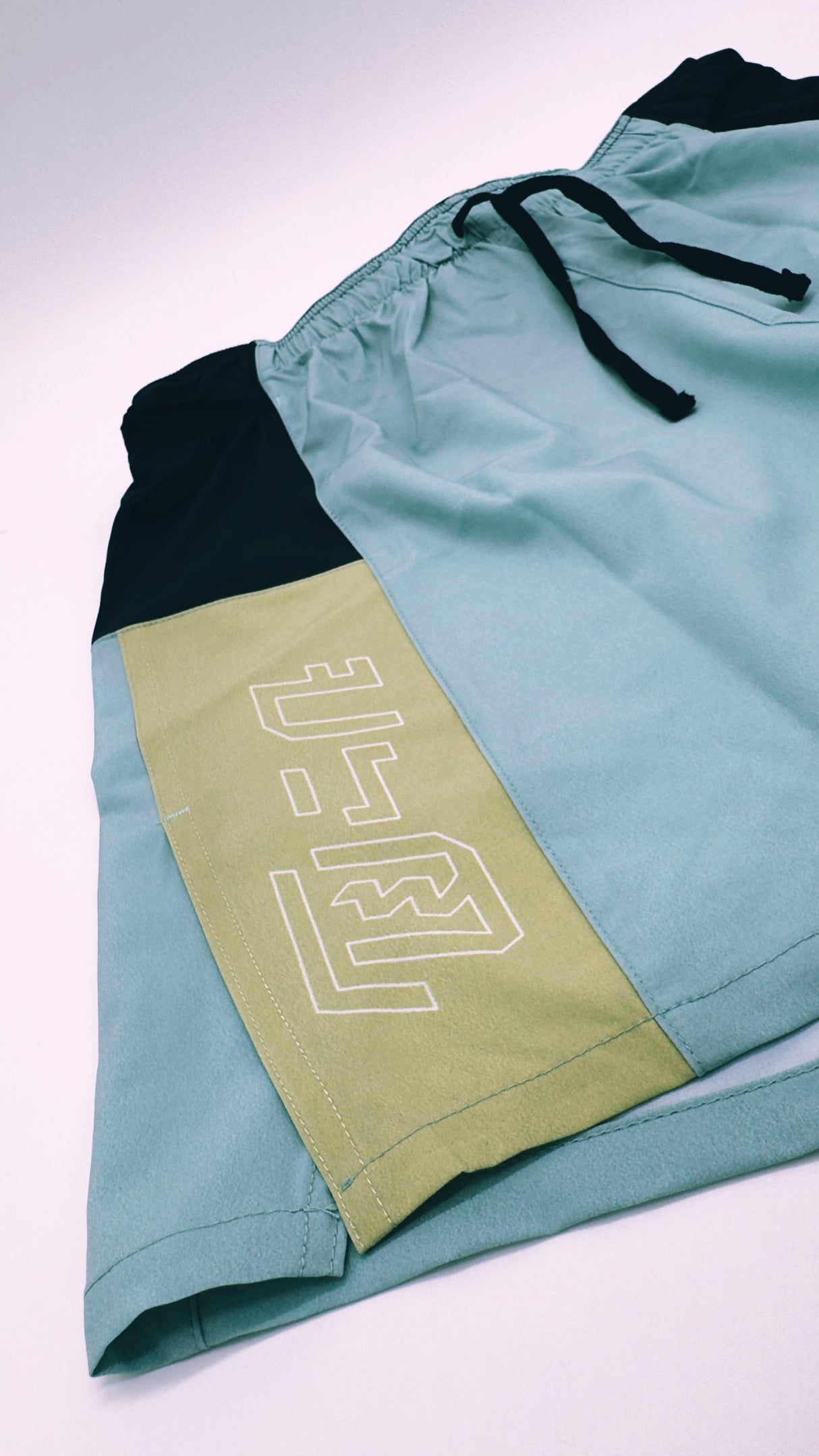 Close-up of Ahon Trail Shorts Pro logo and split side design in Colorway 2