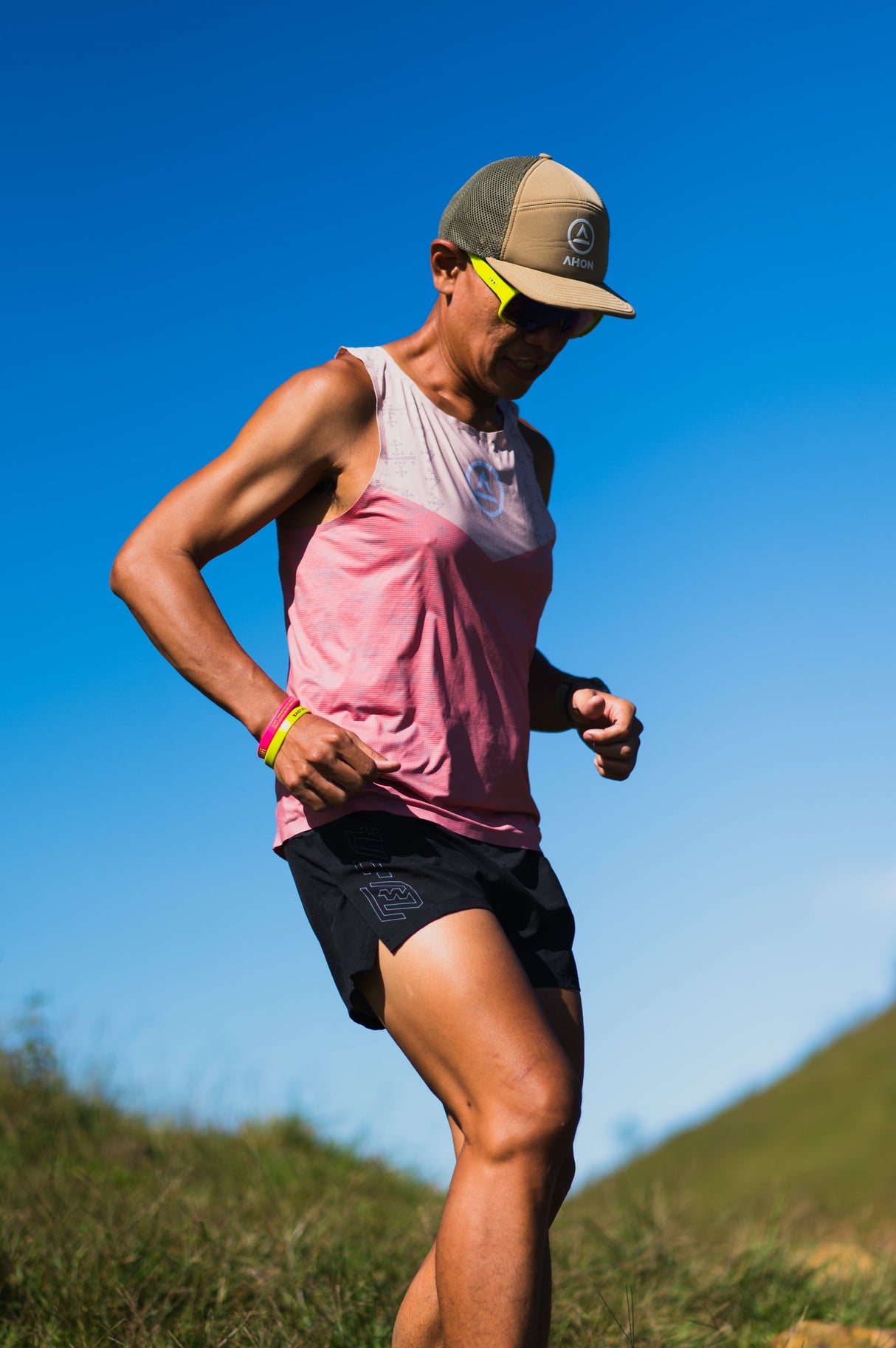 male trail runner wearing Ahon Trail Shorts Pro (Colorway 4) mid-stride on rugged terrain