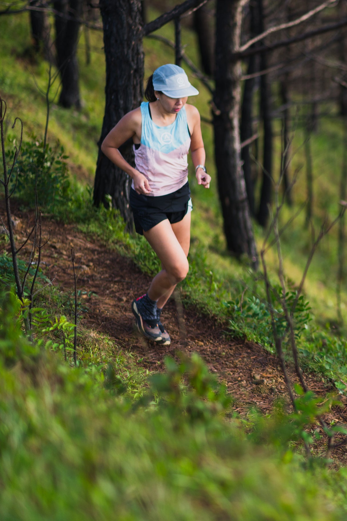 Trail runner wearing Ahon Trail Shorts Pro (Colorway 4) mid-stride on rugged terrain
