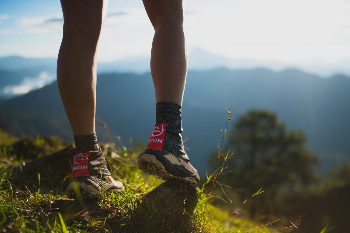 Trail runner wearing Uleyan 1 Gaiters during outdoor run with scenic mountain view