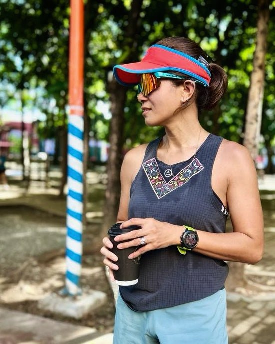 Trail runner outdoors wearing the dark gray Ahon Uleyan singlet in natural light