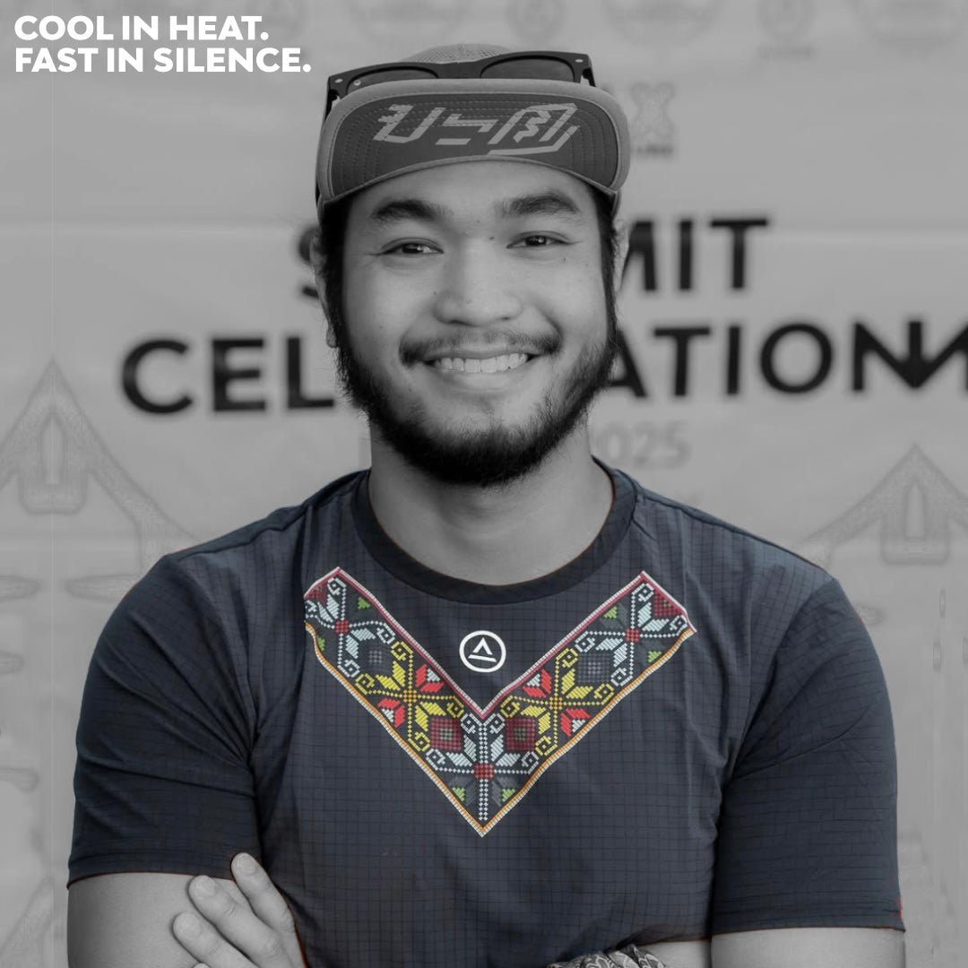 Male trail runner smiling while wearing the Uleyan Super Light SS Shirt in dark gray with colorful woven-inspired chest pattern