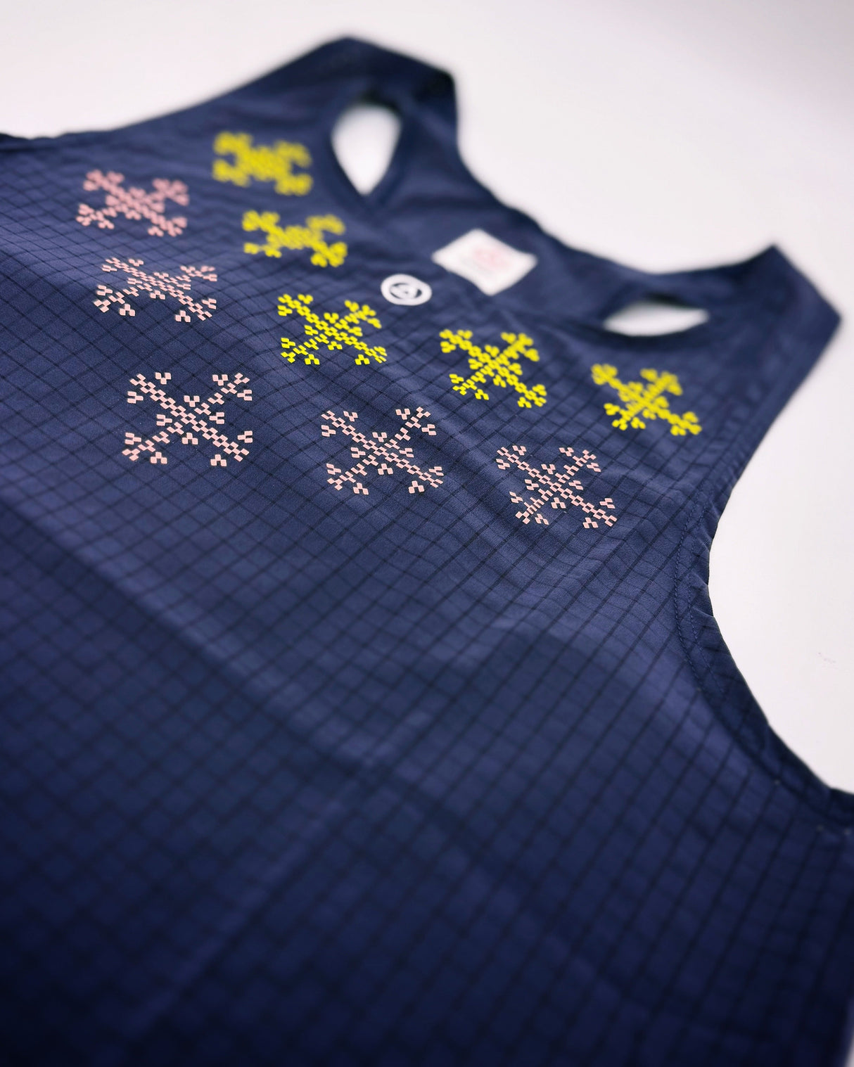 Detailed view of colorful print inspired by Filipino motifs on dark purple singlet.