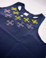 Detailed view of colorful print inspired by Filipino motifs on dark purple singlet.