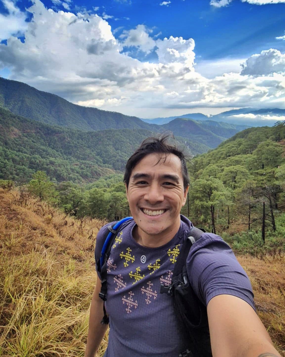 Hiker wearing Ahon’s Apo Super Light Shirt in dark purple, smiling 