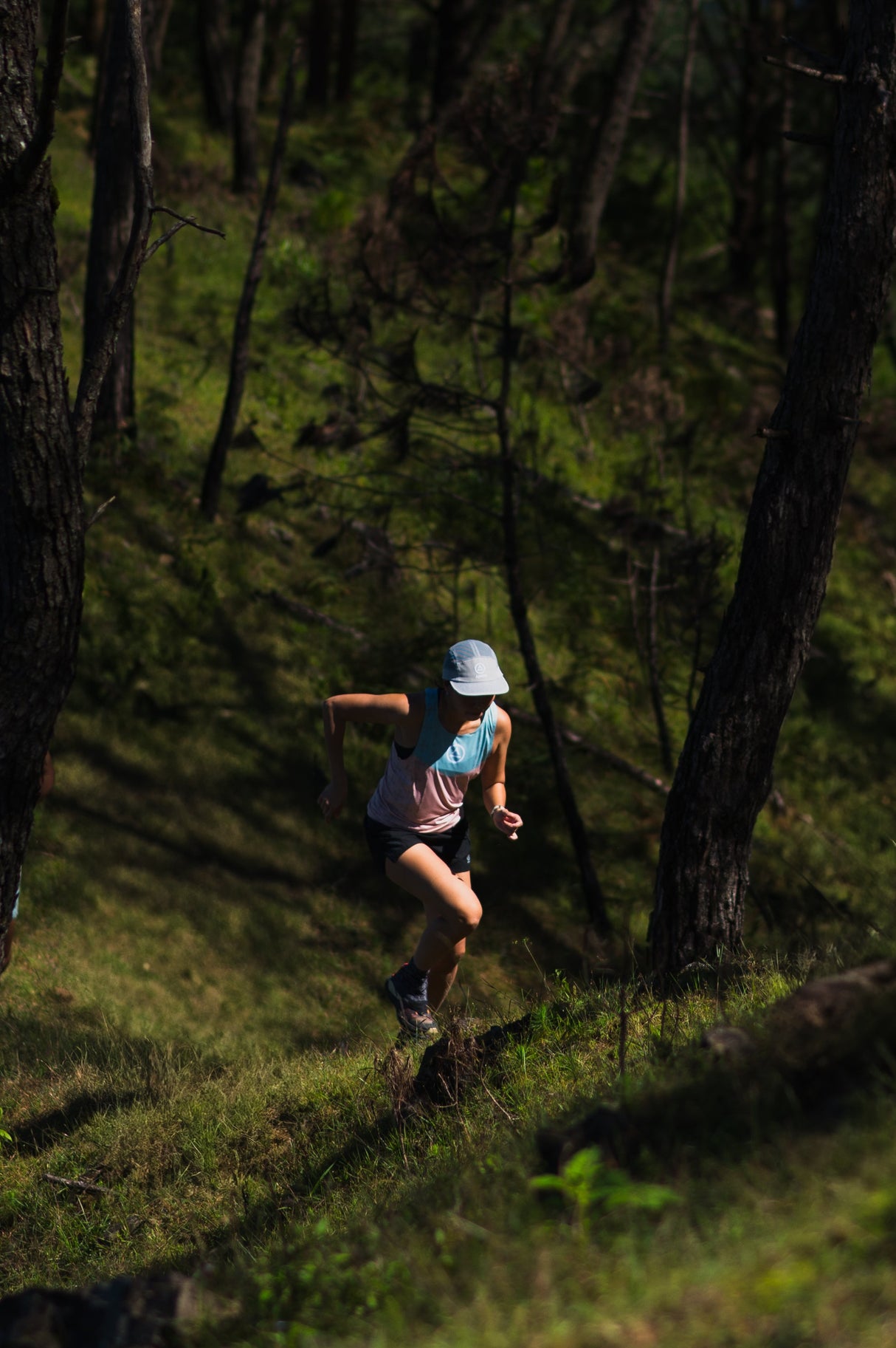 female running up a hill in Ahon Singlet Pro (colorway 3)