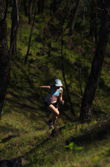 female running up a hill in Ahon Singlet Pro (colorway 3)