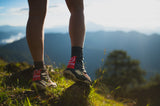 Trail runner wearing Uleyan 1 Gaiters during outdoor run with scenic mountain view